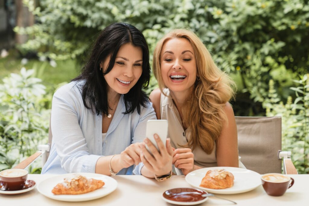 Cheerful smiling laughing two caucasian middle-aged women best friends businesswomen